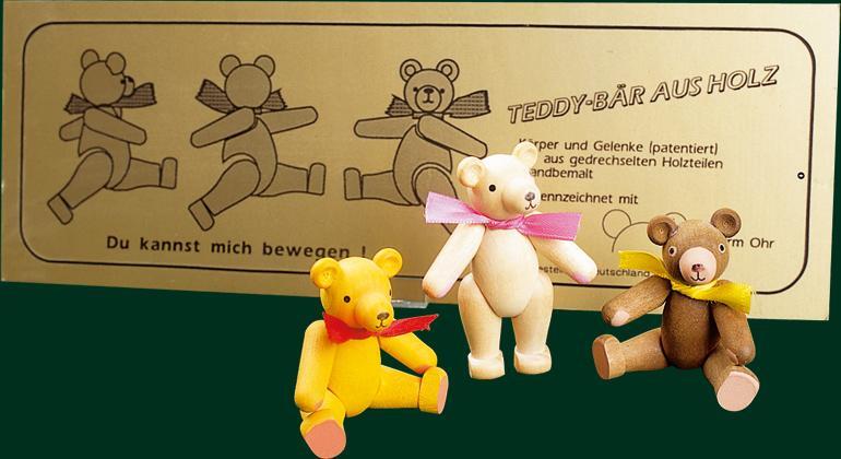 Holzfigur – beweglicher, fröhlicher Bär mit grüner Schleife, gelb – H = 7 cm