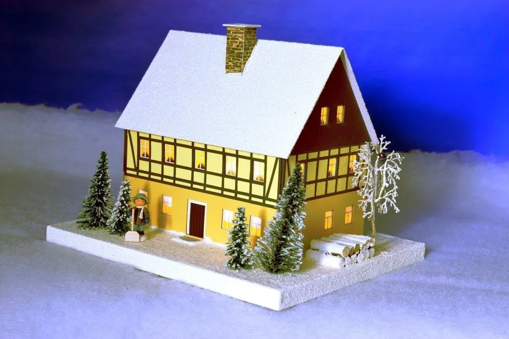 Lichterhaus Fachwerkhaus mit Figur und Beleuchtung aus dem Erzgebirge, verschneites Holzhaus mit