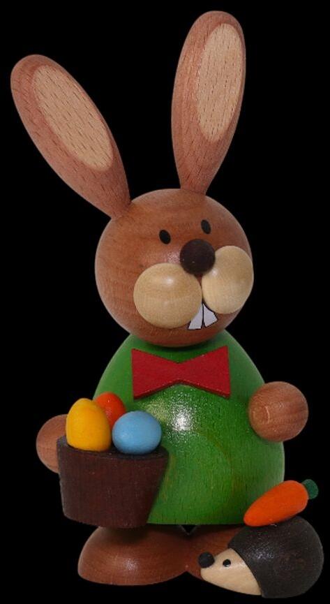 Osterfigur fröhlicher Hase mit Igel und roter Fliege aus Holz, mit bunten Eiern im Korb von