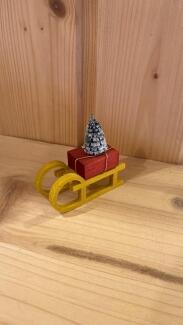 Zubehör – detailreiches Schaf auf fröhlich gelbem Schlitten, handgefertigt – BxHxT = 2 x 5 x 3 cm