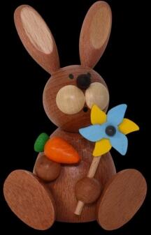 Osterfigur fröhlicher Hase sitzend mit buntem Windrad und Karotte aus Holz von Kunsthandwerk