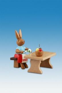 Osterhasen – farbenfrohe Hasenmalerin am Tisch, sitzend mit Pinsel und Osterei – BxHxT ca. 5x7,5x5
