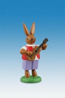 Osterdekoration – farbenfroher Osterhase mit Gitarre als handgefertigte Holzfigur auf Sockel von