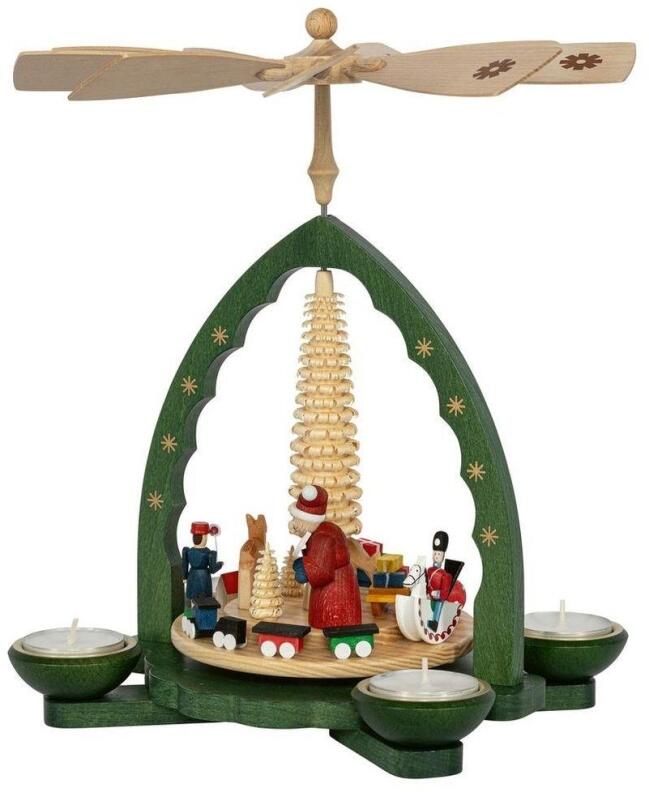 Pyramide Weihnachtsmann bei Bescherung mit drehendem Spielzeug, grünem Bogen und Holzfiguren von