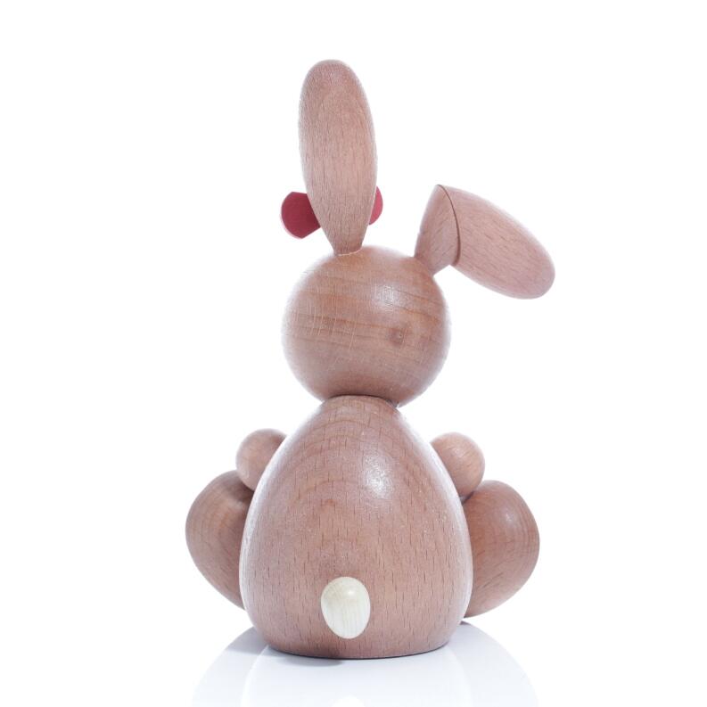 Rückansicht einer sitzenden Osterhäsin mit abgeknicktem Ohr und Brief aus Holz von Kunsthandwerk