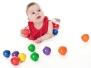 Holzspielzeug bunte klingende Holzkugeln von SINA Spielzeug GmbH, Baby spielt mit farbenfrohen